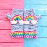 Baby Blue crochet fingerless gloves with pastel rainbow striped cuffs and a pastel rainbow motif with clouds at both ends on the centre of each glove by VelvetVolcano. Kawaii Fairy Kei Style Wrist Warmers