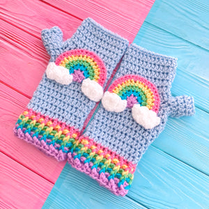 Baby Blue crochet fingerless gloves with pastel rainbow striped cuffs and a pastel rainbow motif with clouds at both ends on the centre of each glove by VelvetVolcano. Kawaii Fairy Kei Style Hand Warmers