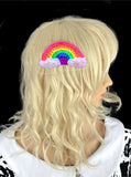 Vibrant neon rainbow crochet hair clip with white clouds at the ends of the rainbow. Neon Rainbow Cloud Hair Accessory by VelvetVolcano