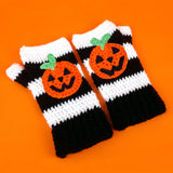 Black and white striped crochet hand warmers with halloween inspired Jack O' Lantern faces. VelvetVolcano Pumpkin Stripe Fingerless Gloves