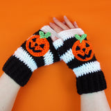 Black and white striped crochet hand warmers with halloween inspired Jack O' Lantern faces. VelvetVolcano Pumpkin Stripe Fingerless Gloves