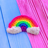 Vibrant neon rainbow crochet hair clip with white clouds at the ends of the rainbow. Neon Rainbow Cloud Hair Accessory by VelvetVolcano