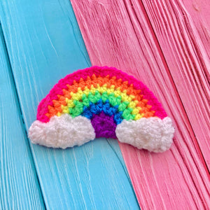 Vibrant neon rainbow crochet hair clip with white clouds at the ends of the rainbow. Neon Rainbow Cloud Hair Accessory by VelvetVolcano