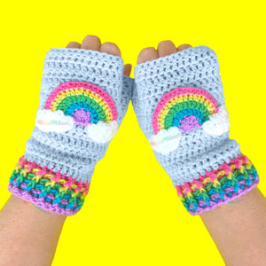 Baby Blue crochet fingerless gloves with pastel rainbow striped cuffs and a pastel rainbow motif with clouds at both ends on the centre of each glove by VelvetVolcano. Kawaii Fairy Kei Style Hand Warmers