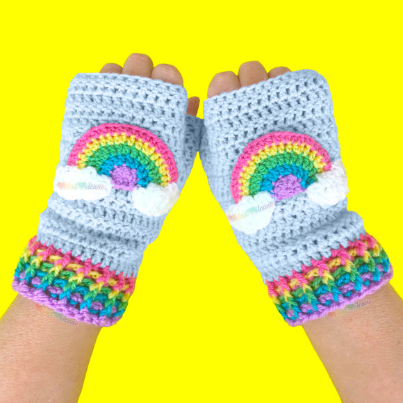 Baby Blue crochet fingerless gloves with pastel rainbow striped cuffs and a pastel rainbow motif with clouds at both ends on the centre of each glove by VelvetVolcano. Kawaii Fairy Kei Style Hand Warmers