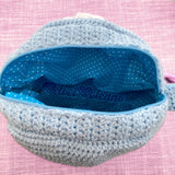 The inside of a Duck Egg Blue Pastel Rainbow Cloud crochet bag by VelvetVolcano showing a blue and white polka dot fabric