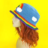 Dolphin blue crochet bucket hat with rainbow cloud motif and rainbow striped hat brim by VelvetVolcano