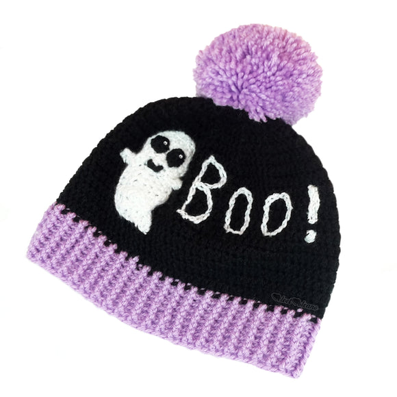 Black crochet bobble hat with white smiley ghost and white BOO! lettering and lilac pom pom and ribbed brim. BOO! Ghost Custom Colour Pom Pom Beanie by VelvetVolcano