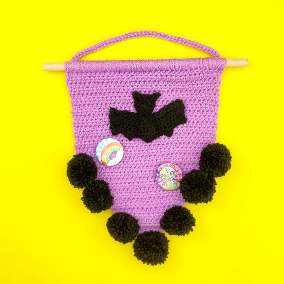 Bat Pennant Wall Hanging by VelvetVolcano - Lilac Crochet Wall Hanging attached to a wooden dowel with a black bat motif and black pom pom trim.