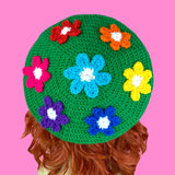 Grass green crochet beret with daisy design, each flower a different rainbow colour. Bright Rainbow Daisy Daze Beret by VelvetVolcano