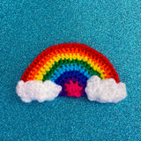 Crochet rainbow hair clip with white clouds at both ends of the rainbow - Bright Rainbow Cloud Hair Clip by VelvetVolcano