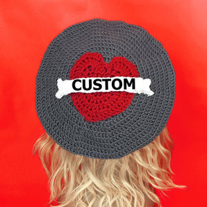 Grey crochet beret with red heart in the centre and a white tattoo style banner over the top that says "Custom" in black text. Love Heart Banner Beret (Custom Colour / Text) by VelvetVolcano