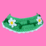 A light green crocheted Peter Pan collar with a white scalloped trim and a repeating daisy chain design on the main part of the collar by VelvetVolcano