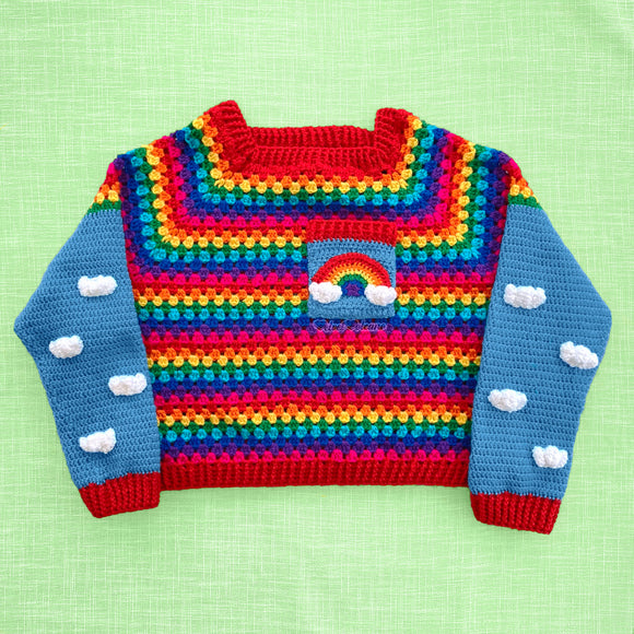 Cropped Crochet Bright Rainbow Cloud Jumper / Sweater with grey blue sleeves that have a white cloud pattern and red cuffs and a chest pocket with a rainbow and white clouds by VelvetVolcano