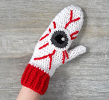 White crochet mittens with red cuffs and eyeball design including red blood vessels. Eye See You Mittens by VelvetVolcano