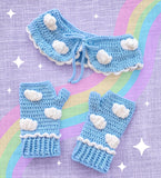 Light Blue crochet Peter Pan style collar with white cloud pattern and white scallop trim around the bottom edge. The collar fastens with braided light blue ties. There is also a pair of matching fingerless gloves that has the scallop trim around the start of the cuff. - Cloud Collar and Fingerless Gloves by VelvetVolcano