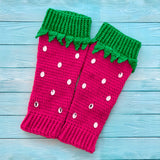 Hot pink crochet leg warmers designed to look like strawberries with emerald green top cuffs that feature little green leaves and silver rhinestone seeds by VelvetVolcano
