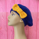 Navy blue crochet beret with a mustard yellow bow on the side by VelvetVolcano