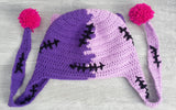 Half lilac, half violet Frankenstein's Monster inspired crochet cat ear, ear flap beanie with cerise pink inner ears and pom poms. Custom Colour FrankenKitty Ear Flap Beanie by VelvetVolcano