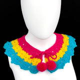 Crocheted Peter Pan Collar in a lacy chevron type stitch in the pansexual pride flag colours - hot pink, yellow and turquoise. The collar fastens with hot pink braided ties and mini pom poms.