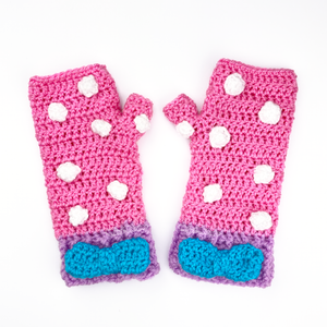Bubblegum Pink crochet hand warmers with white polka dot pattern, lilac cuffs and a turquoise bow in the centre of the cuff. Polka Dot Bow Fingerless Gloves (Custom Colour) by VelvetVolcano 