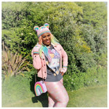 Ayesha, a black woman with pastel rainbow coloured long hair is wearing VelvetVolcano Pastel Rainbow Cloud Double Pom Pom Beanie and Pastel Rainbow Cloud Fingerless Gloves along with a pastel kawaii outfit, jewellery and makeup.