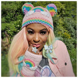Ayesha, a black woman with pastel rainbow coloured long hair is wearing VelvetVolcano Pastel Rainbow Cloud Double Pom Pom Beanie and Pastel Rainbow Cloud Fingerless Gloves along with a pastel kawaii outfit, jewellery  and makeup.
