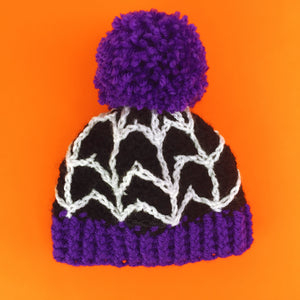 Black crochet babies bobble hat with white cobweb design, purple pom pom and purple bottom rib. Spider Web Pom Pom Beanie (Baby - Child Sizes) (Custom Colour) by VelvetVolcano