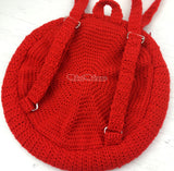 The back of a crochet curcular shaped backpack showing the straps and silver d rings and adjusters