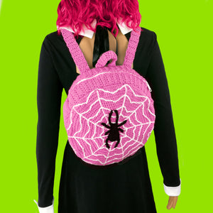 Bubblegum Pink, White and Black crocheted circular shape backpack with cobweb and spider design by VelvetVolcano