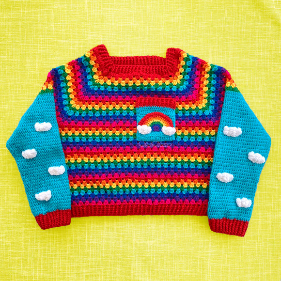 Bright Rainbow striped crocheted cropped jumper with Turquoise sleeves with White cloud applique pattern and a chest pocket with a rainbow and cloud motif by VelvetVolcano