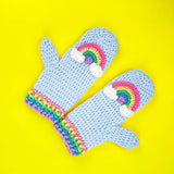 Light blue crochet mittens with pastel rainbow and cloud design and pastel rainbow striped cuffs by VelvetVolcano