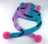 Half lilac, half turquoise Frankenstein's Monster inspired crochet cat ear, ear flap beanie with bubblegum pink inner ears and pom poms. Custom Colour FrankenKitty Ear Flap Beanie by VelvetVolcano