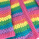 Close up view of the cuffs and pocket detail of a VelvetVolcano Pastel Rainbow Striped Cardigan