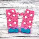 Bubblegum Pink crochet hand warmers with white polka dot pattern, lilac cuffs and a turquoise bow in the centre of the cuff. Polka Dot Bow Fingerless Gloves (Custom Colour) by VelvetVolcano