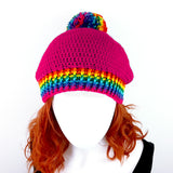 Cerise / Hot Pink slouchy crochet bobble hat with rainbow pom pom and rainbow striped brim by VelvetVolcano