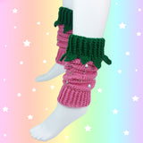 Bubblegum pink crochet leg warmers designed to look like strawberries with emerald green top cuffs that feature little green leaves and silver rhinestone seeds by VelvetVolcano